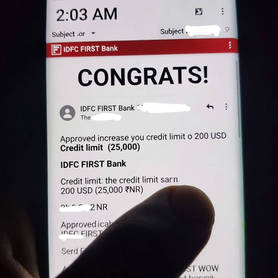 Cropped IDFC WOW approval email screenshot with thumb in frame